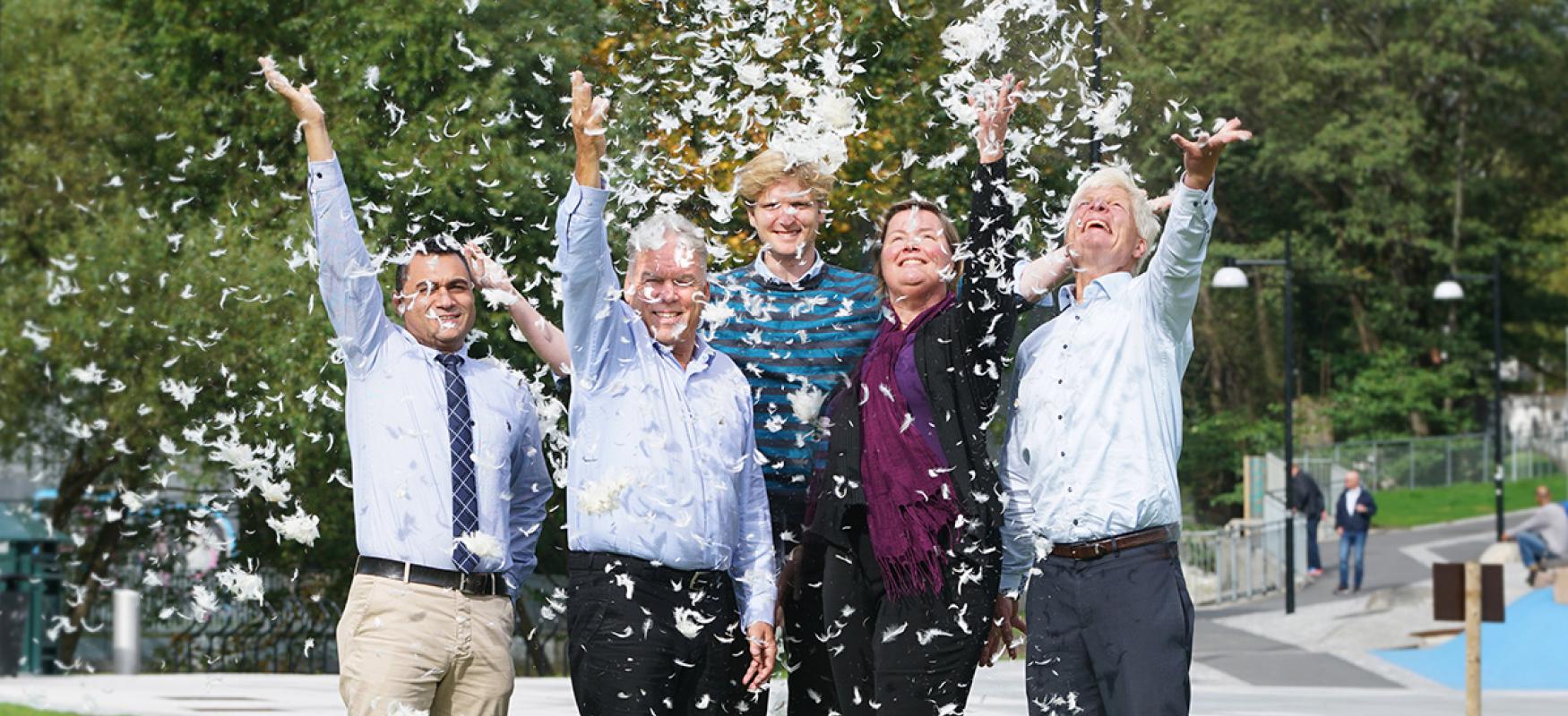 The project team throwing feathers into the air.