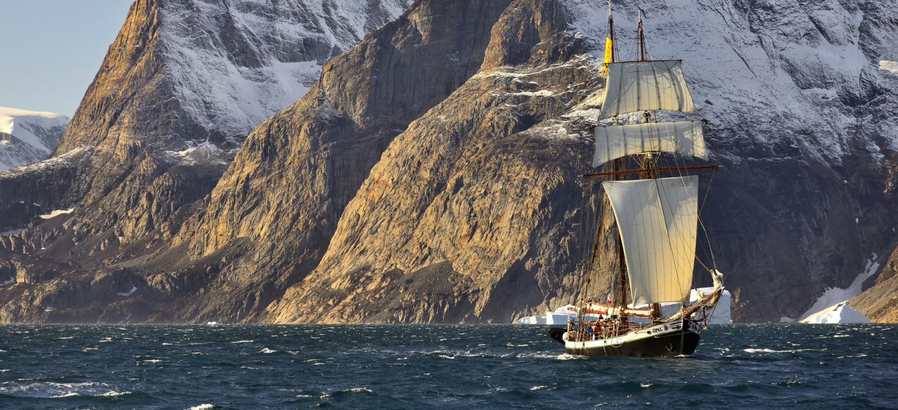 Ship sailing with mountains in the background