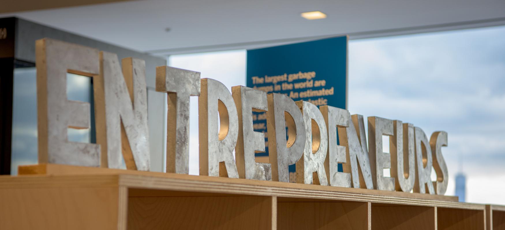 Letters on top of a bookcase spelling out "entrepreneurs", New York 2019.