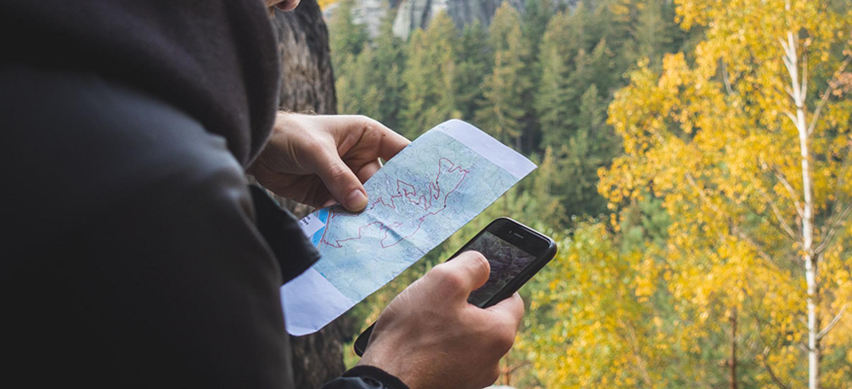 Man holding a map and a mobile