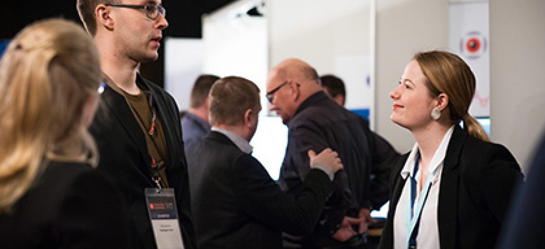 People discussing infront of an exhibition stand.