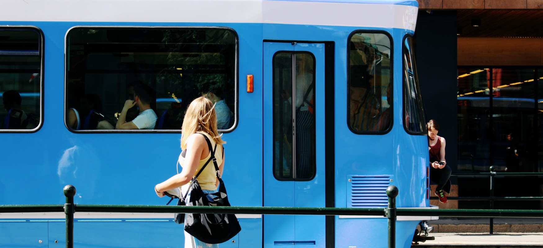 Tram in Oslo driving by on a sunny day.