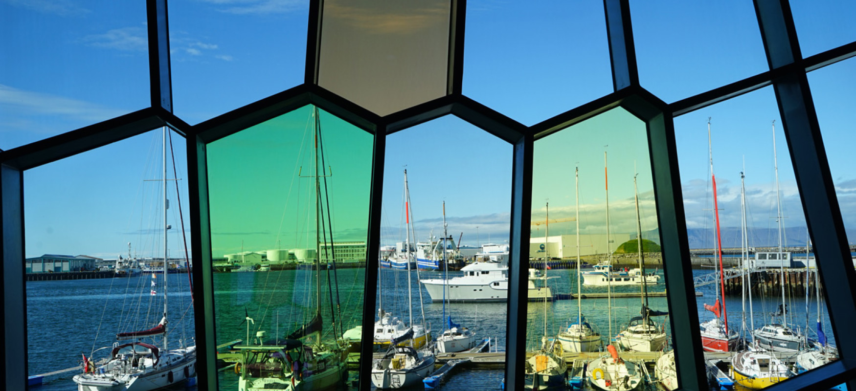 View of a harbor in Reykjavik from inside a building with colored glass