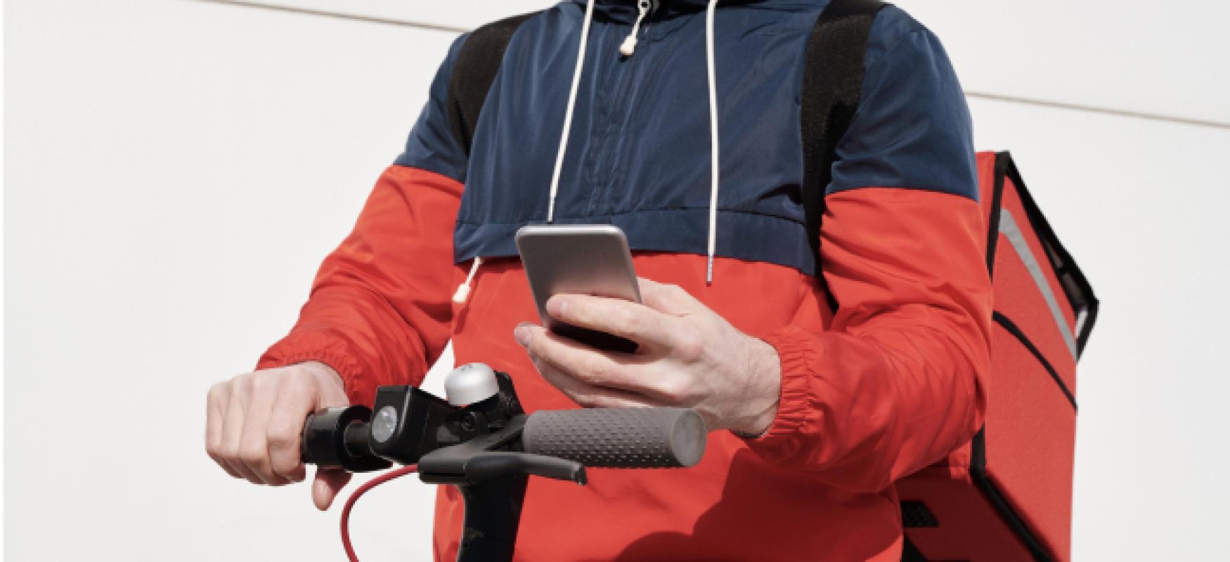 Young man on a electrical scooter using GPS on smartphone