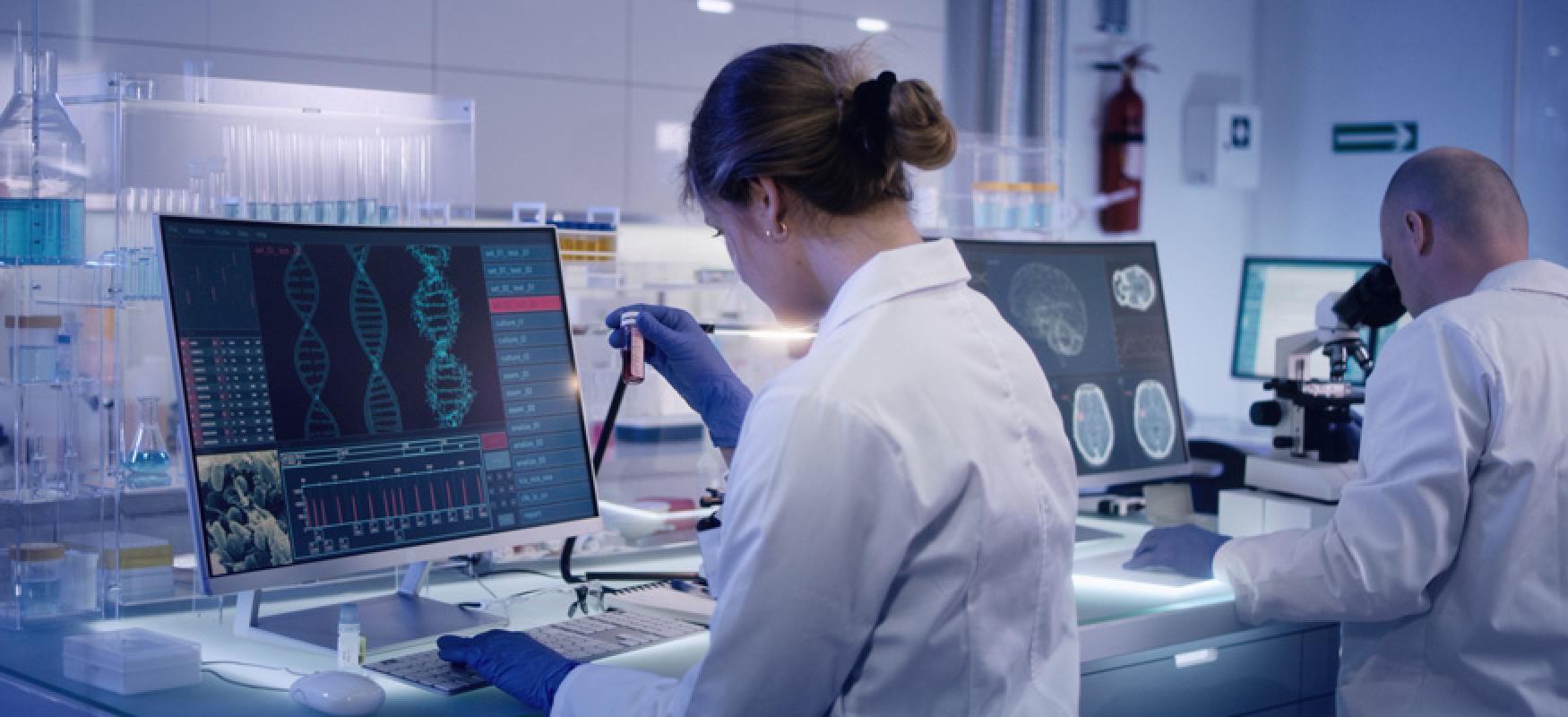 Two scientists in white lab coats in a lab