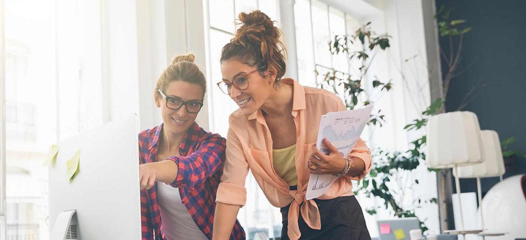 Two women are looking at a computer screen
