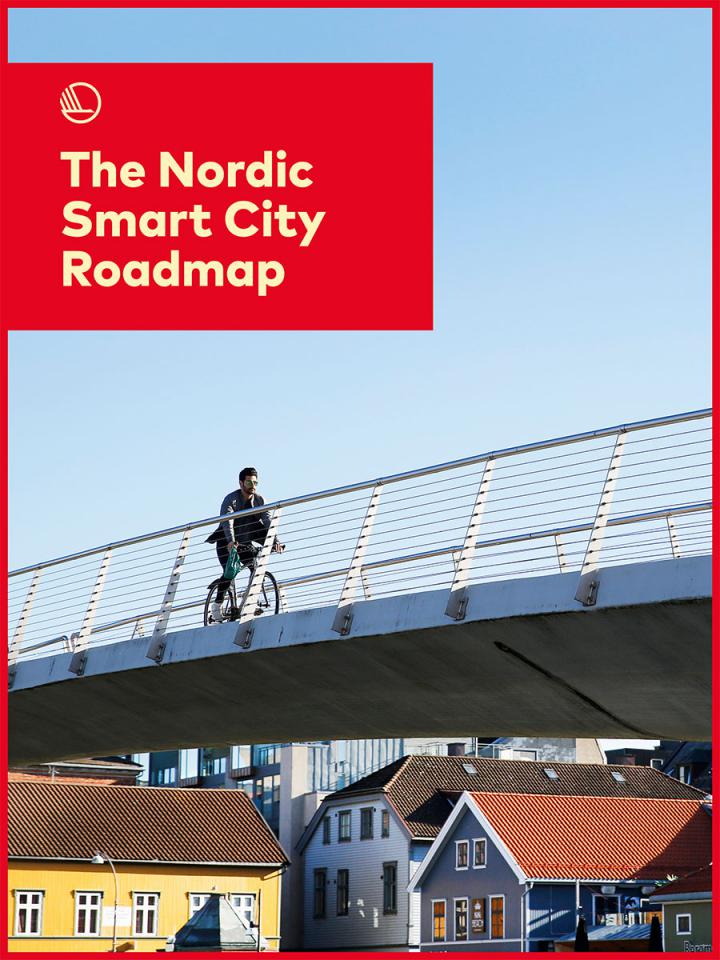 Publication frontpage showing a cyclist crossing a bridge with wooden houses in the background.