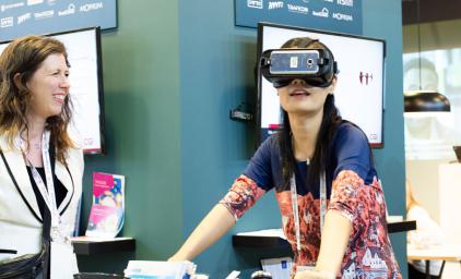 Female visitor at the Nordic pavilion testing VR tech at ITS World Congress 2019 in Singapore.