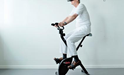 Eldre og digitalisering. Eldre person på trimsykkel med VR-briller.