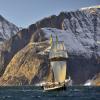 Ship sailing with mountains in the background