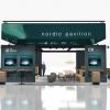Green pavilion with Nordic ITS logos and screens surrounded by light coloured wooden chairs.