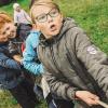 Children in a field playing tug of war